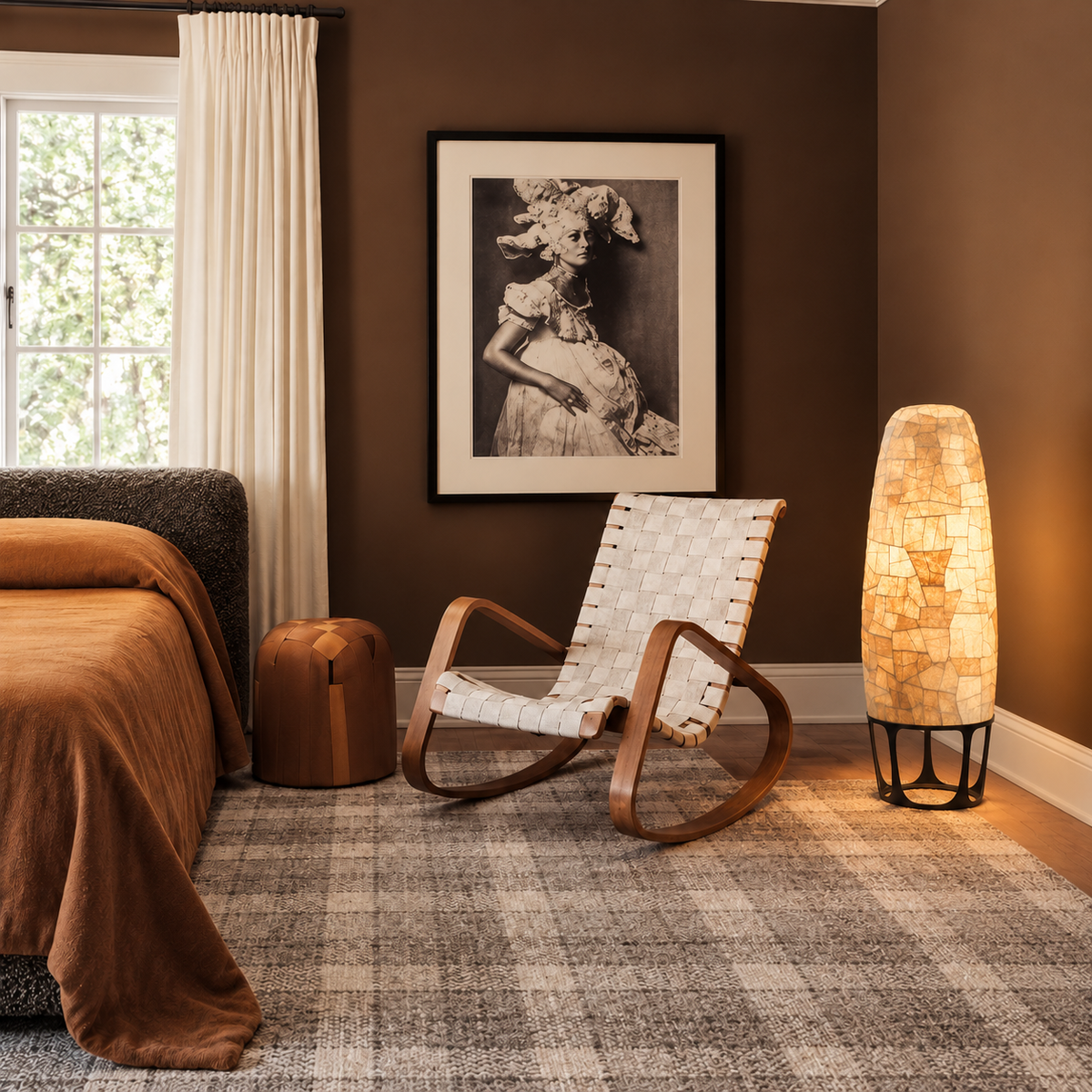 Appia floor lamp beside a woven rocking chair in a brown bedroom with ochre bedding.