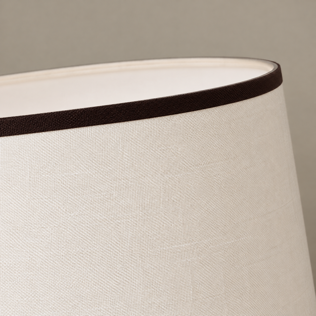 Close view of the cream woven shade fabric and narrow dark brown upper binding.