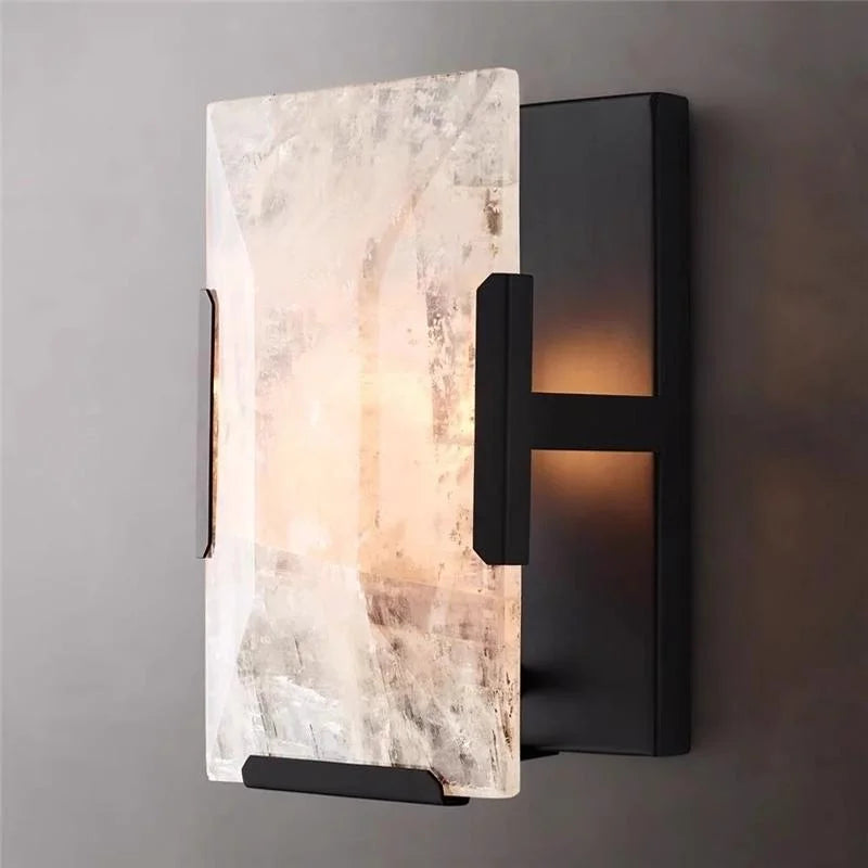 Black calcite sconce beside a mirror