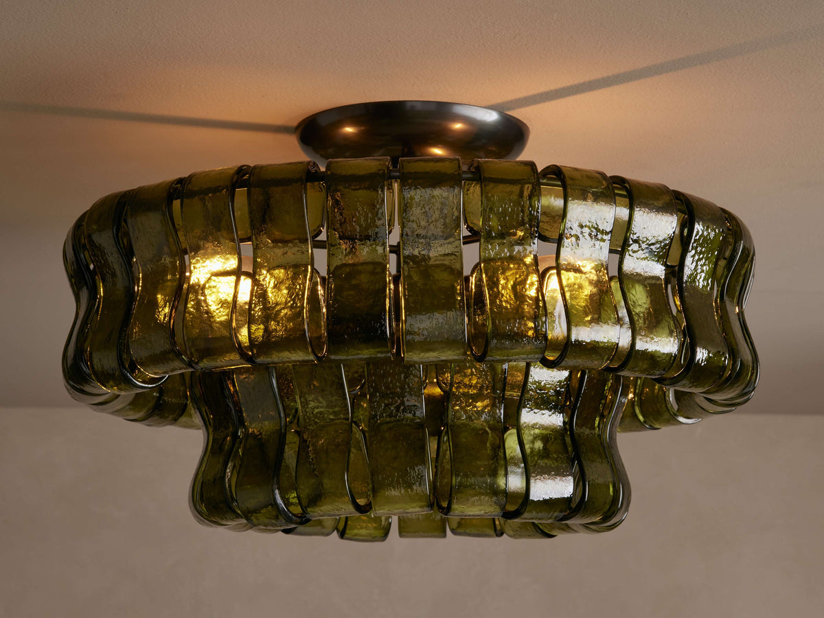 Bellatrix green glass semi-flush mount lit, warm light glowing through the overlapping panels