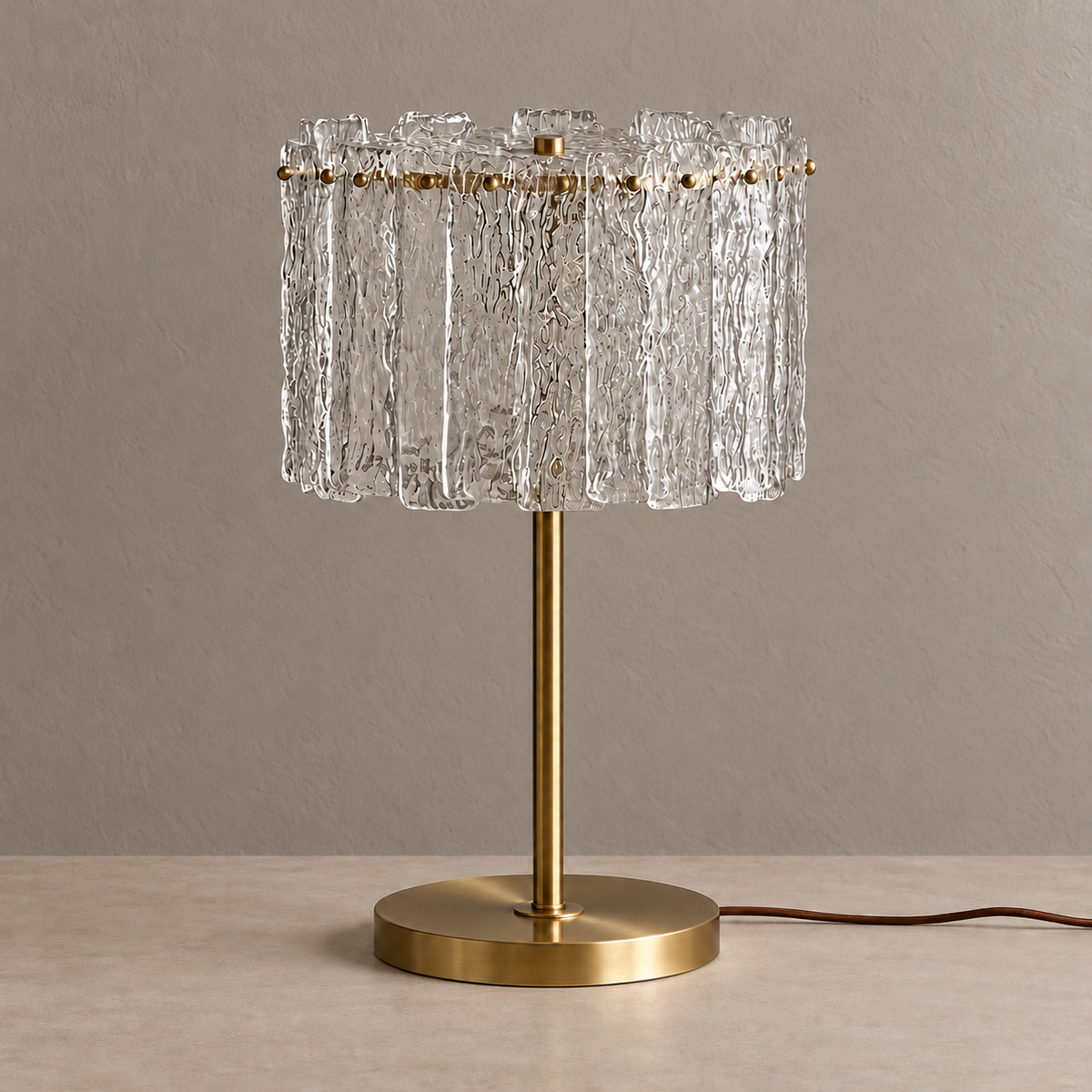 Unlit CLAZS99S glass and brass table lamp against a stone-beige background.