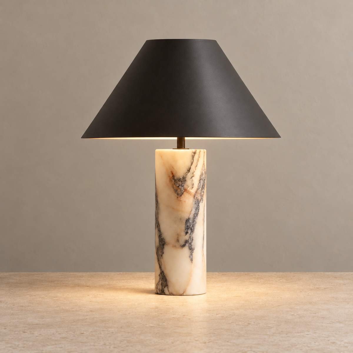 Black and marble table lamp illuminated beneath its shade.