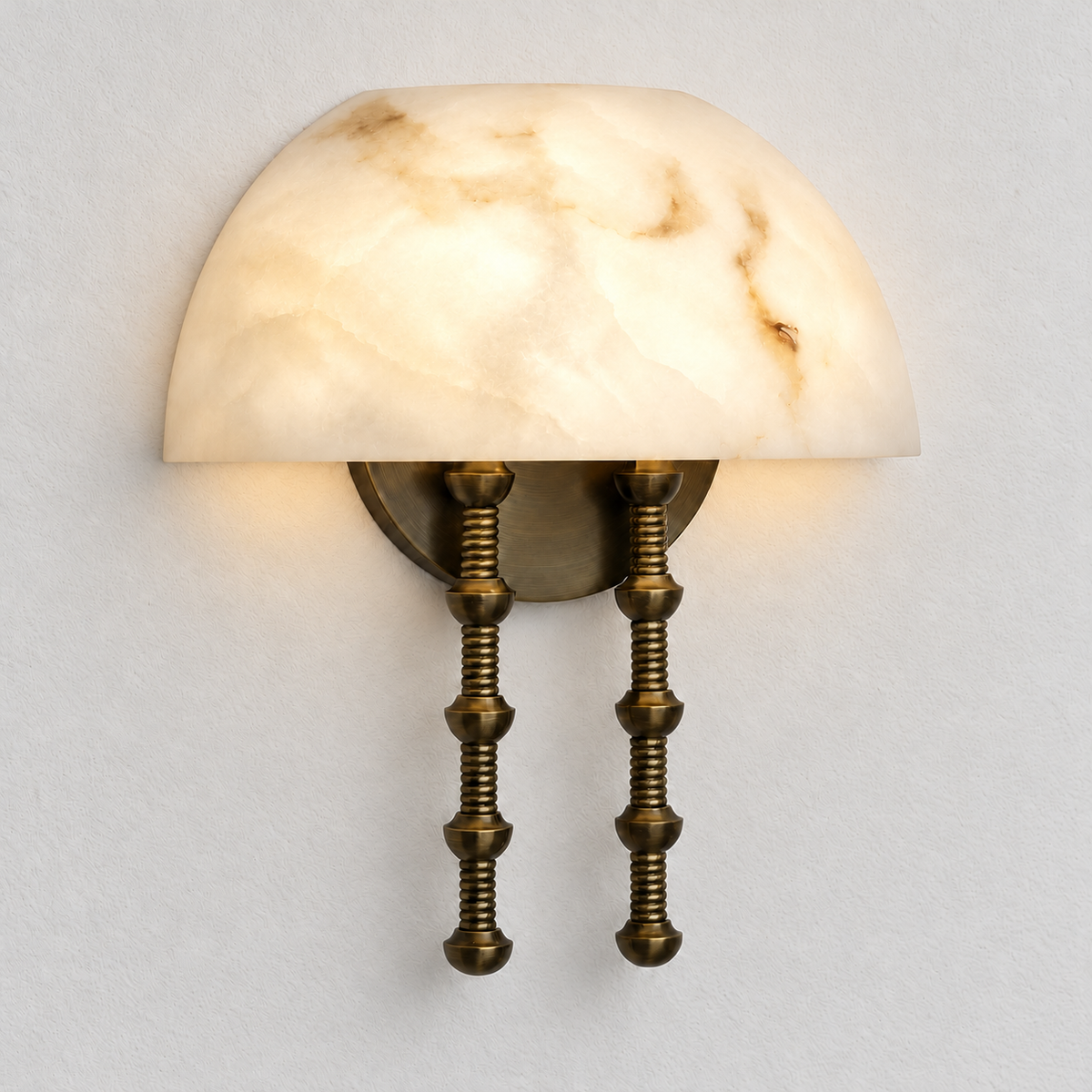 Alabaster dome wall sconce illuminated on warm ivory.