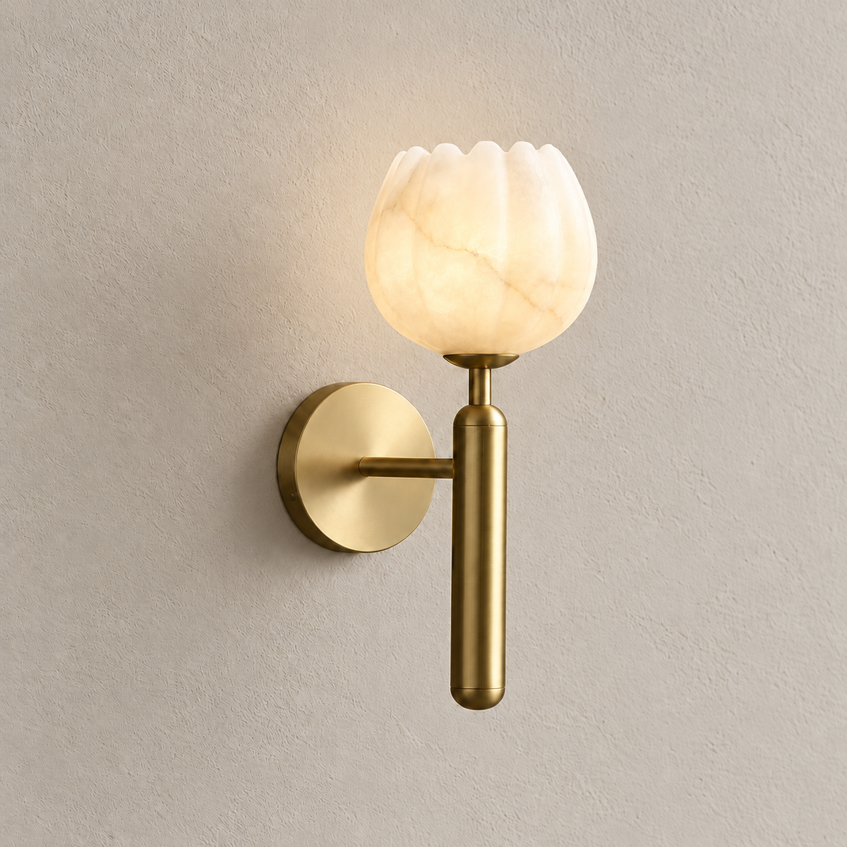 Alabaster tulip wall sconce with a brass stem illuminated in the matching ivory composition.