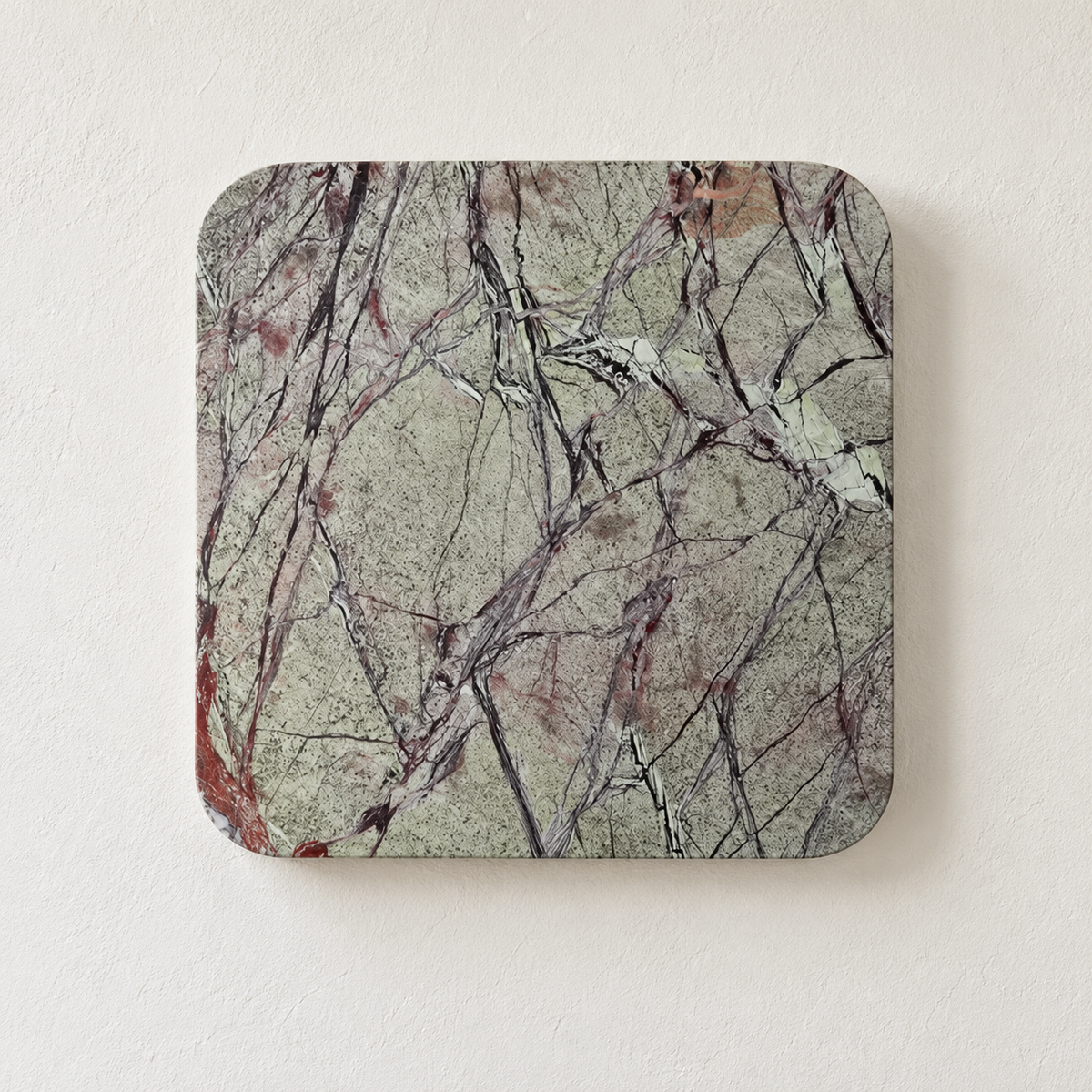 Square green marble wall light with dark natural veining, switched off on ivory plaster.