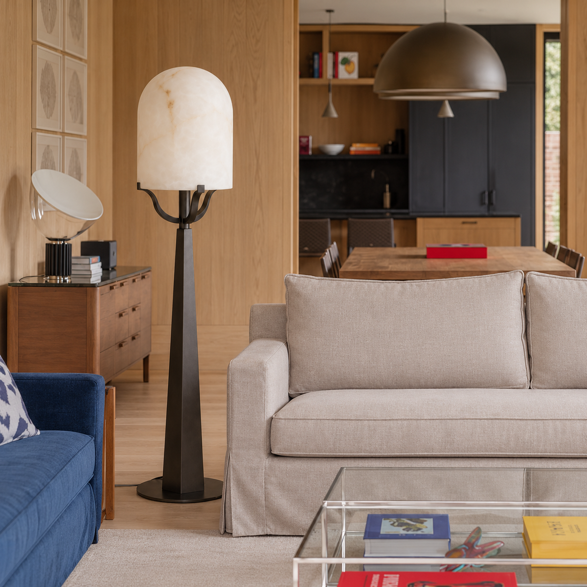 Svolti alabaster floor lamp beside a linen sofa in a wood-panelled living room.