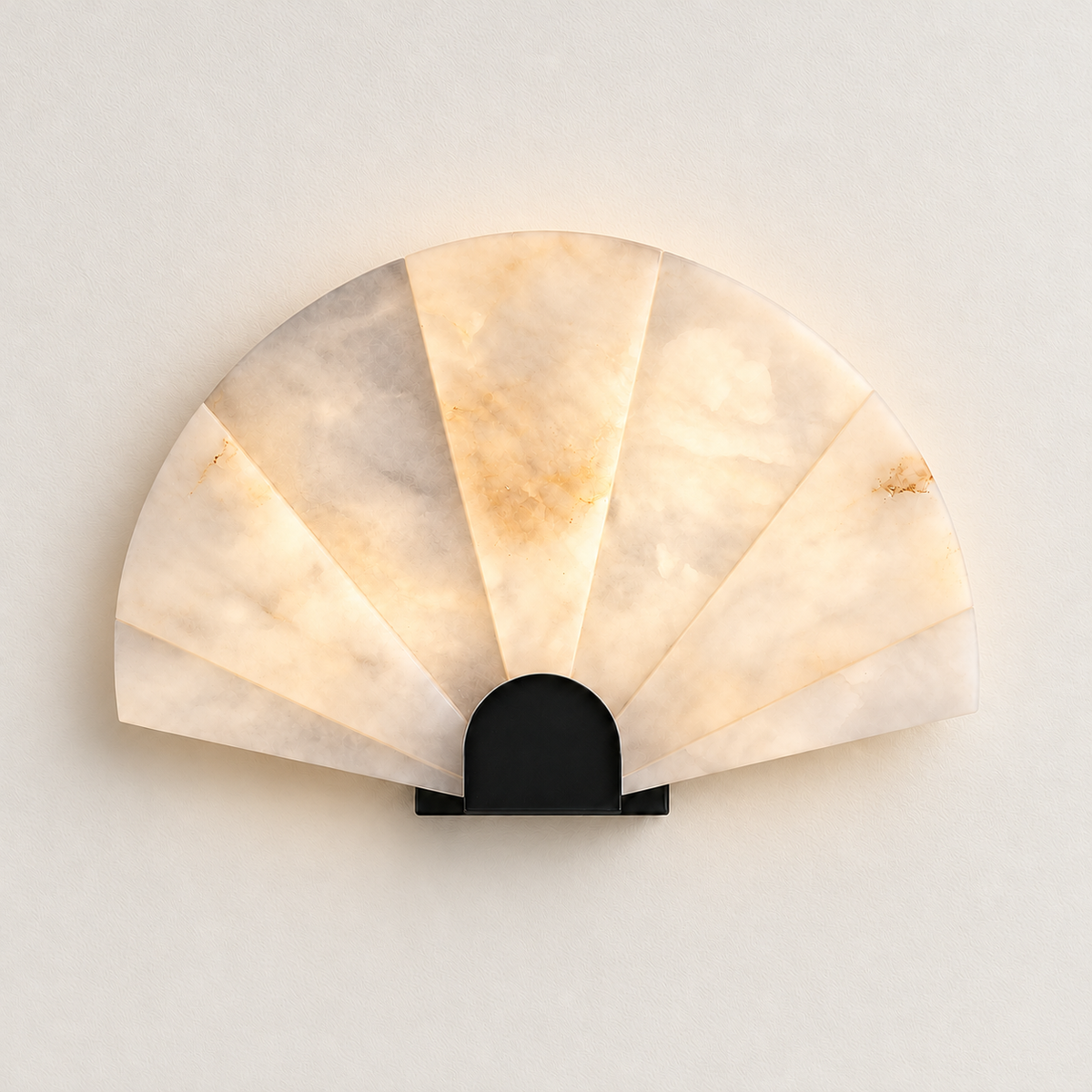 Alabaster fan sconce illuminated, showing its radial stone sections.