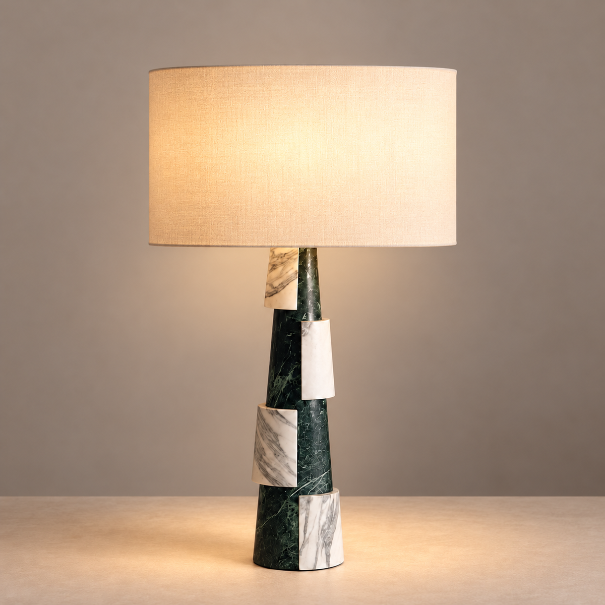 Green and white marble table lamp with illuminated linen shade.