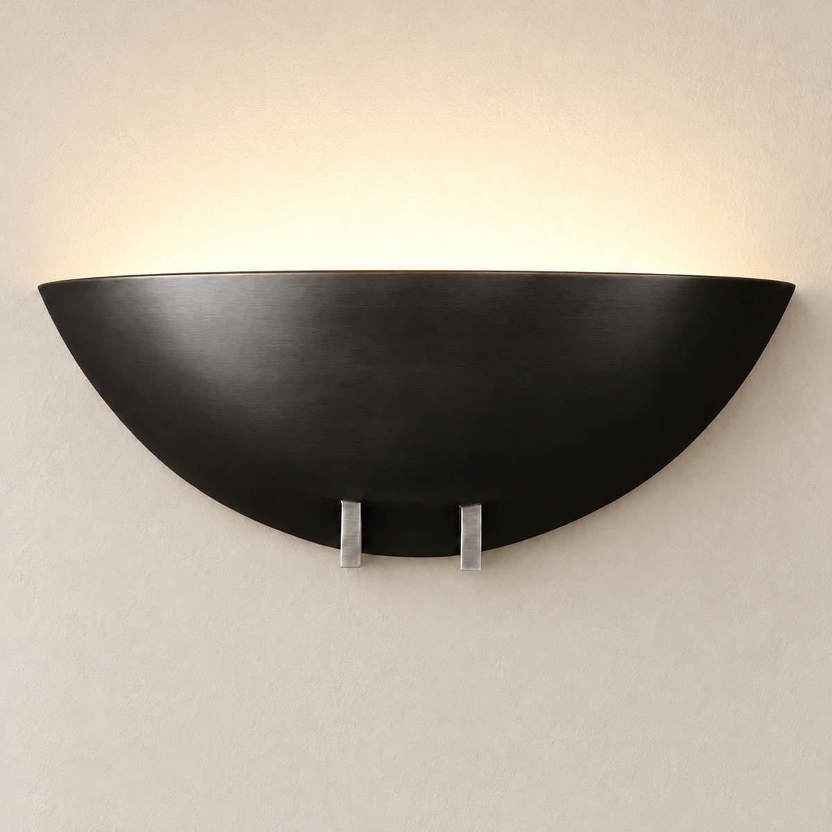 Black bowl wall sconce illuminated on the same beige wall.