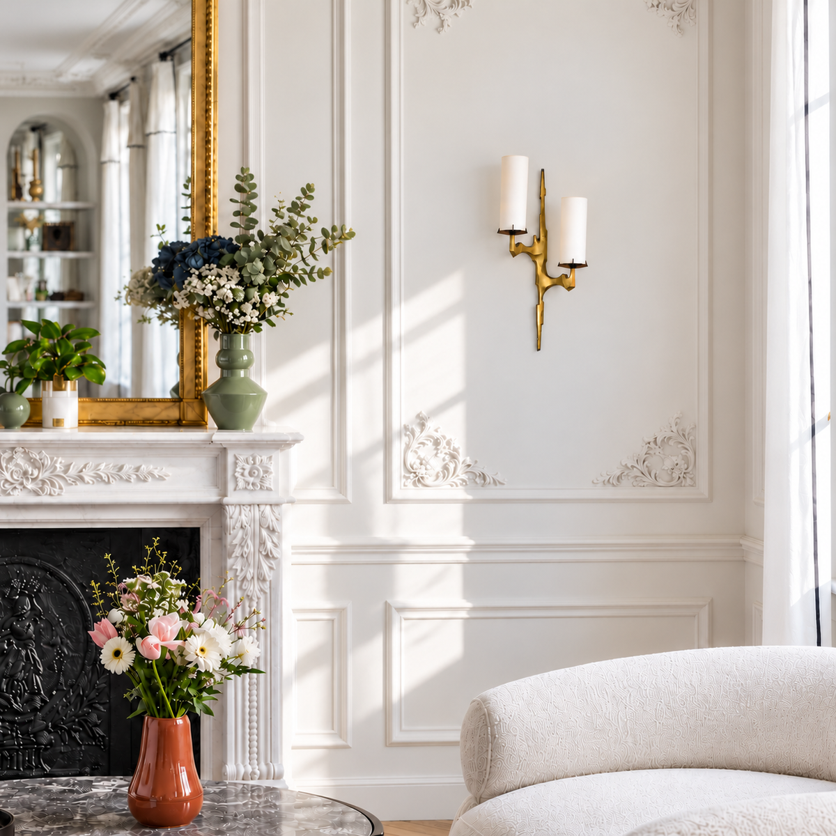 Sculptural brass sconce with two staggered opal glass shades mounted in a daylight living room.