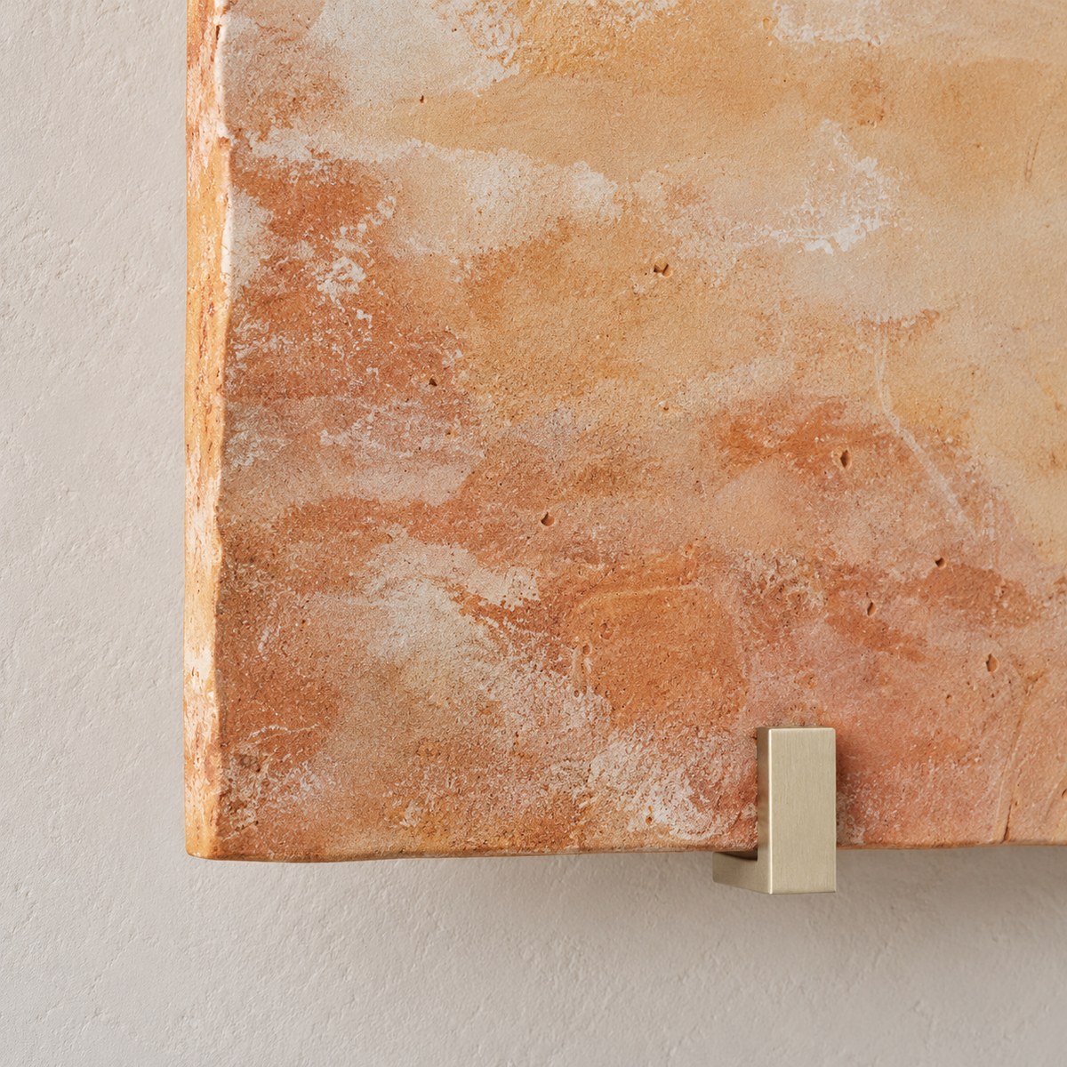 Close-up of hand-fired terracotta texture and a metal retaining clip on the Parefeuille Petite sconce.