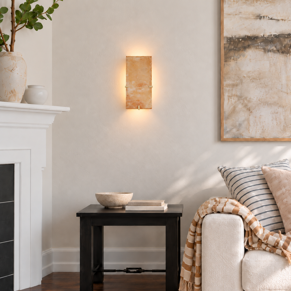 Backlit terracotta wall sconce above a side table beside a cream sofa in a naturally lit living room.