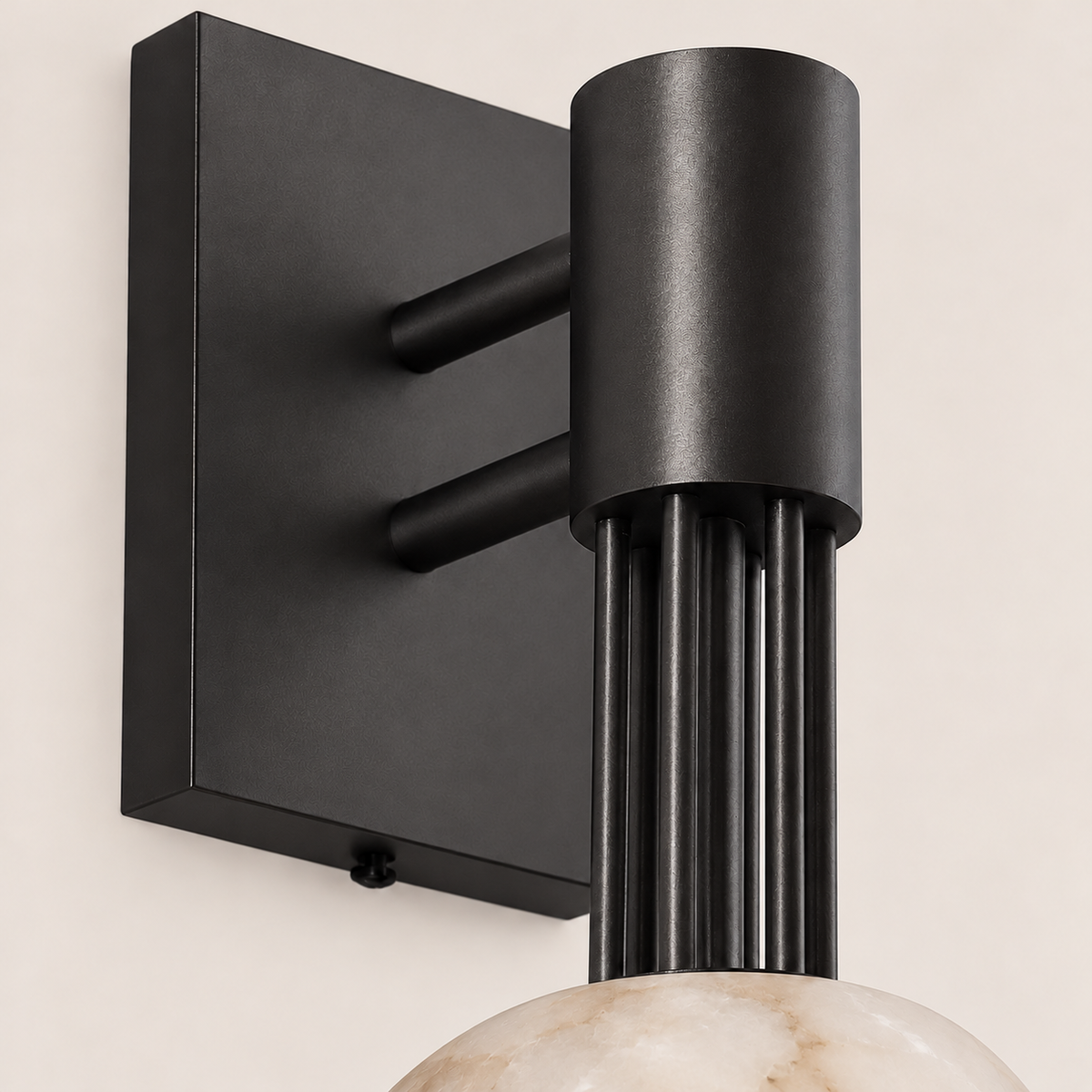 Detail of the black sconce's twin support arms, rectangular backplate and vertical rods.