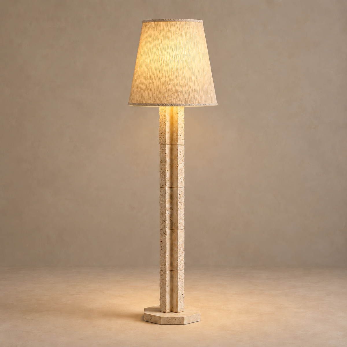 CLJFR53 floor lamp illuminated through its tapered fabric shade above the travertine column.
