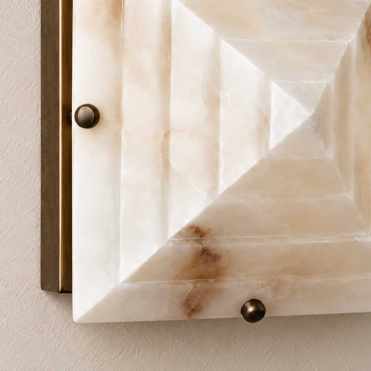 Detail of the stepped alabaster surface and brass fixing hardware.