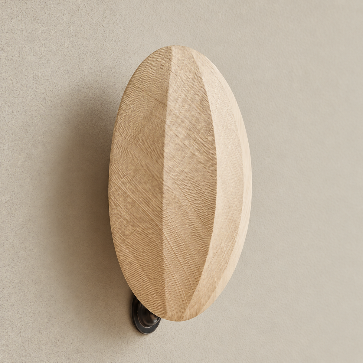 Oak disc wall sconce, switched off on a beige wall.