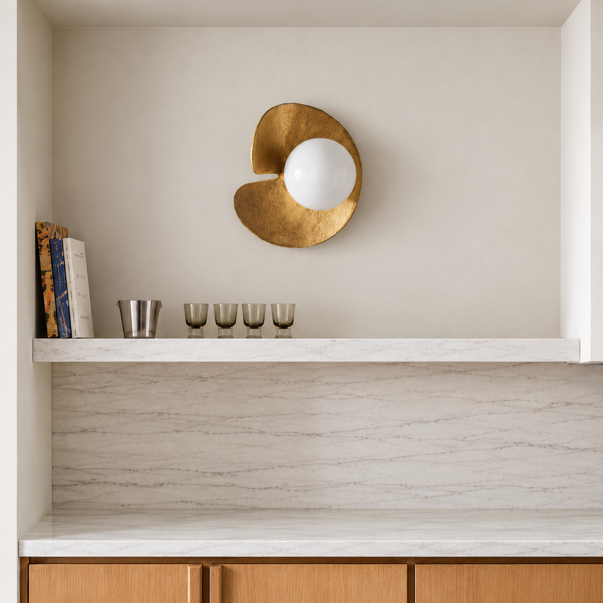 Aulia copper wall sconce above a marble backsplash and light oak kitchen cabinets.