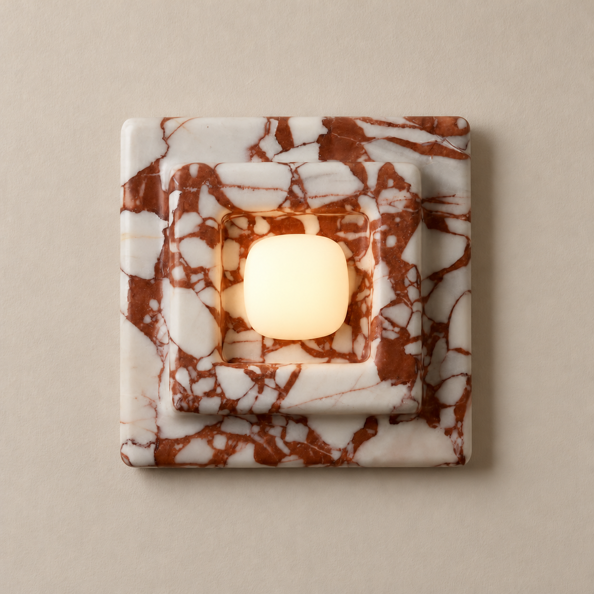 Red marble square wall sconce with its central opal diffuser illuminated.
