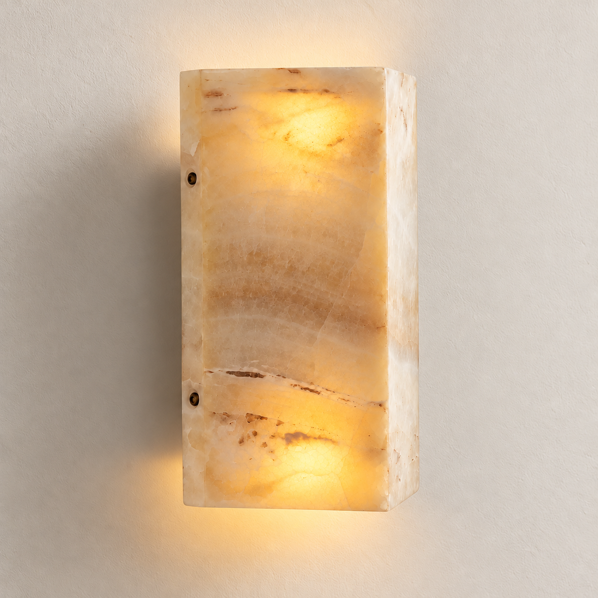 Cream jade wall sconce illuminated at the top and bottom, revealing the stone’s natural markings.