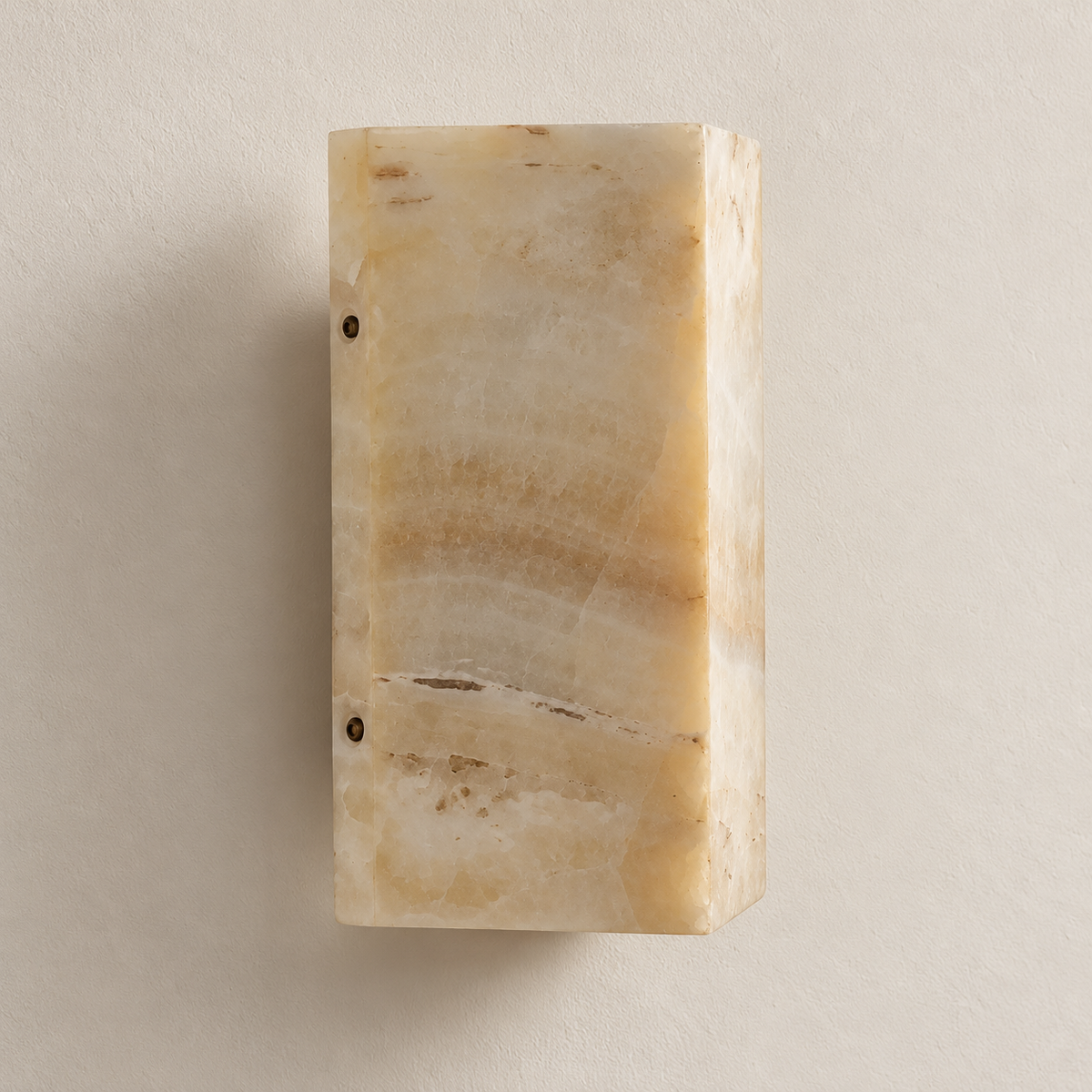 Unlit cream jade wall sconce with a curved stone face and dark retaining bolts.