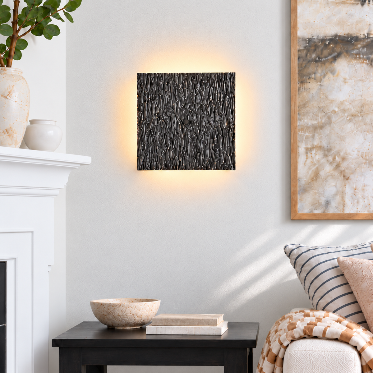 Dark Ratera square wall sconce on an ivory wall beside a living-room chair and fireplace.
