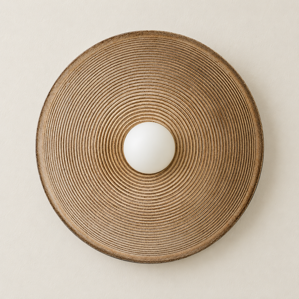 Front view of the taupe ceramic disc wall lamp with concentric ridges and an unlit glass globe.