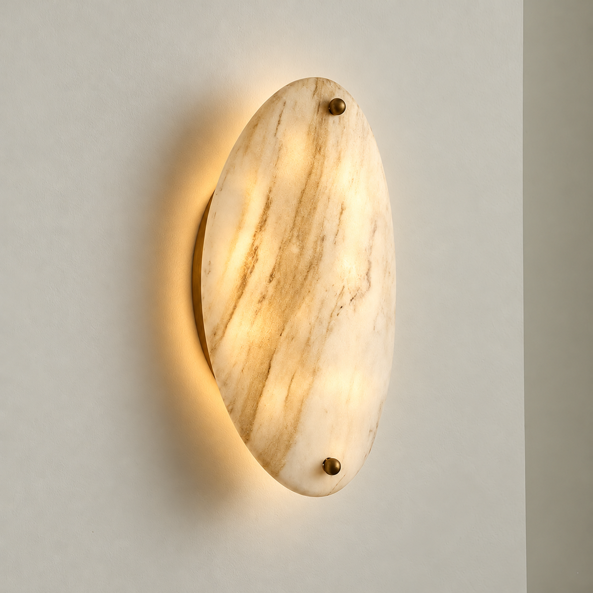 Oval marble wall sconce illuminated on warm ivory.