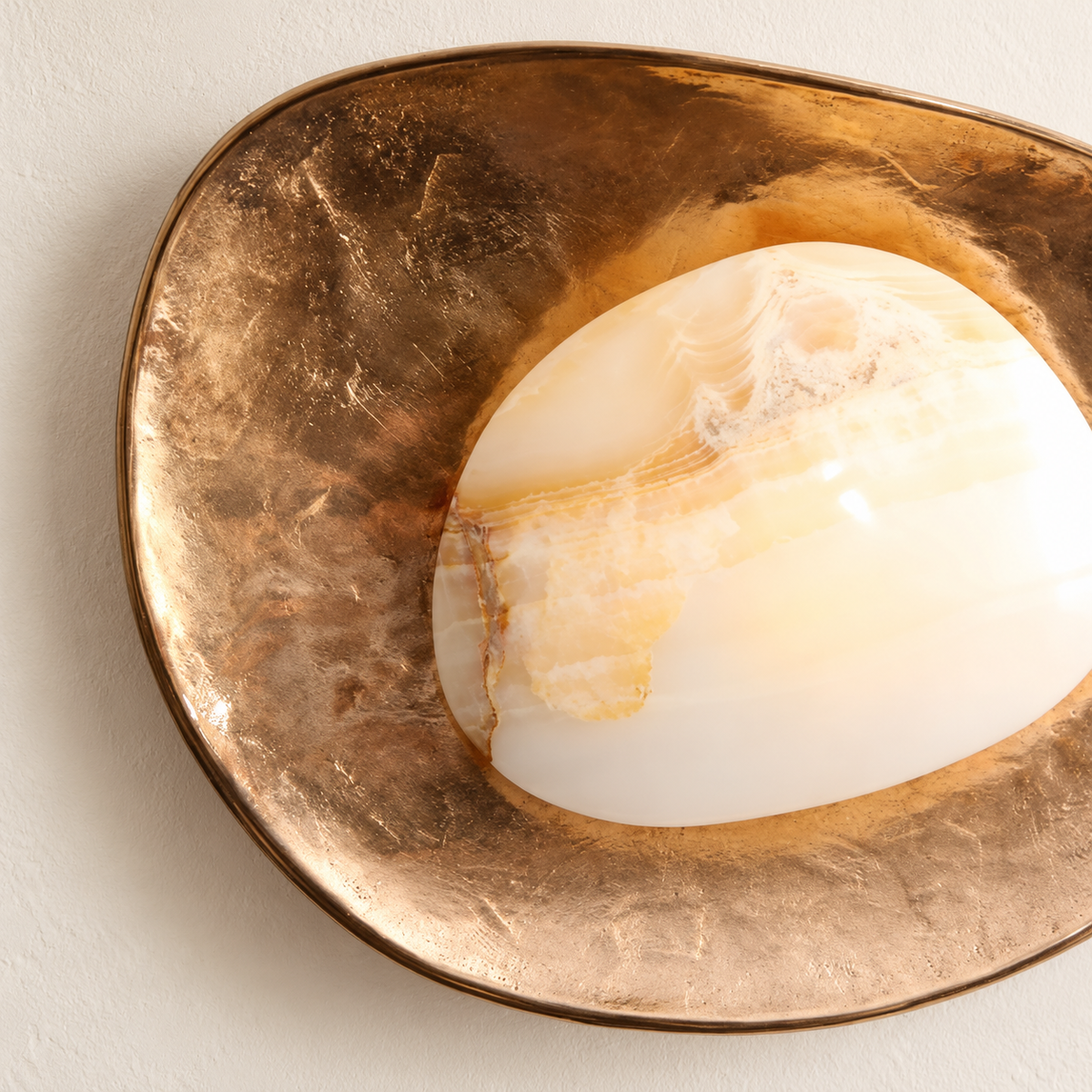 Close-up of the honey-veined stone panel and textured brass reflector.