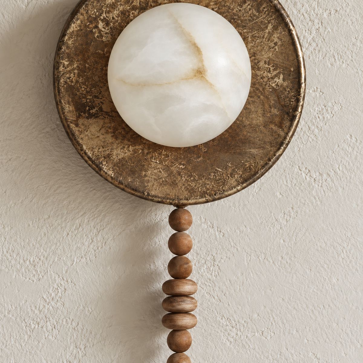 Close-up of the sconce’s veined alabaster lens, patinated rim and upper wood beads.