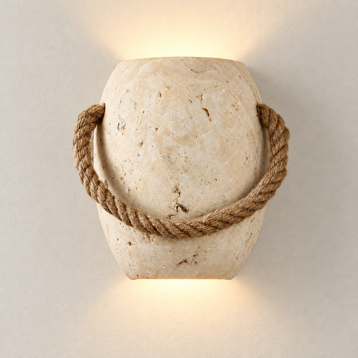 Travertine and rope sconce casting light above and below on an ivory wall.