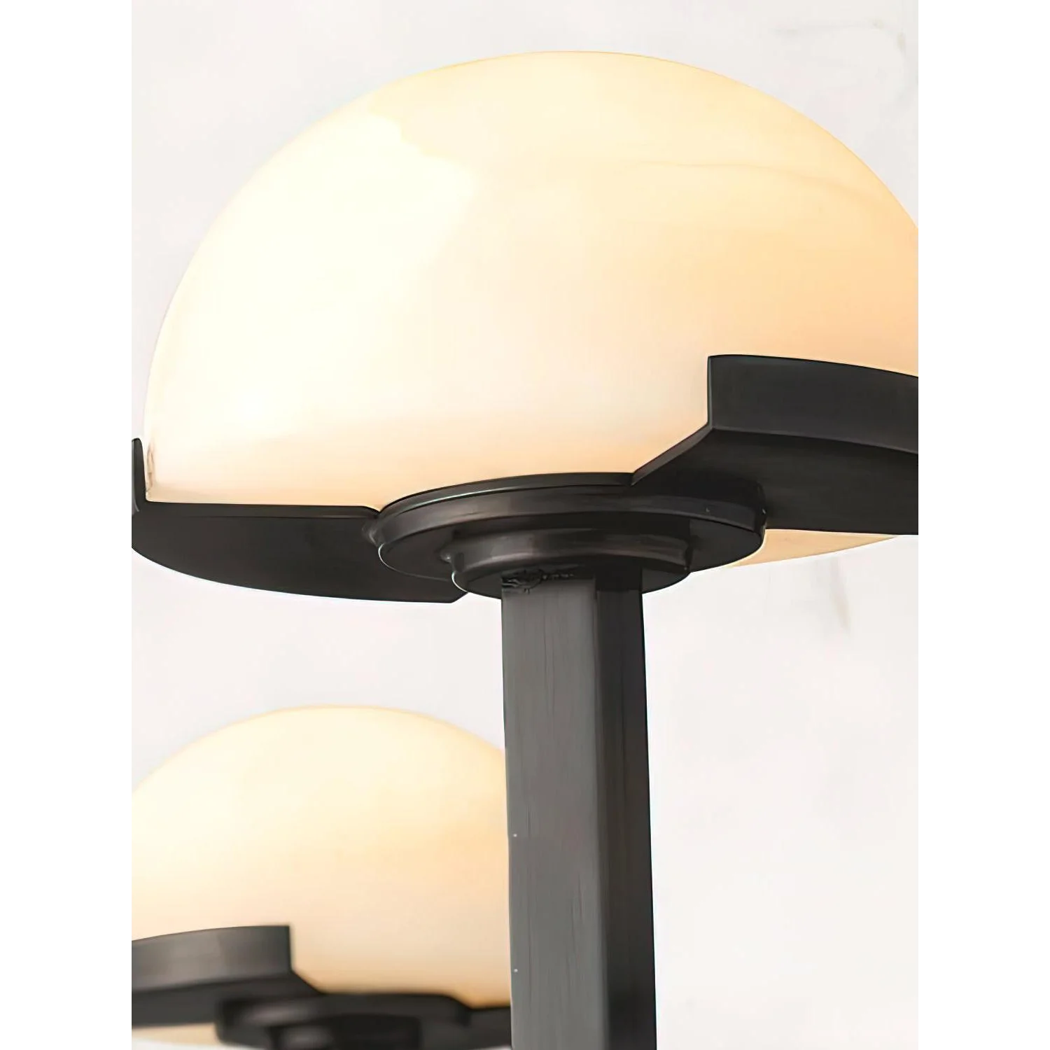 Black double alabaster sconce beside a mirror
