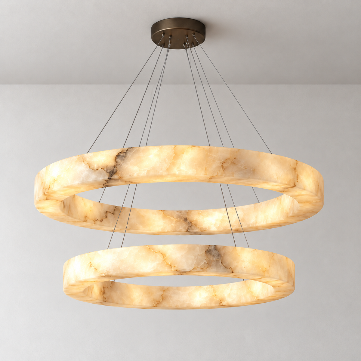 Double alabaster ring chandelier with black canopy, illuminated; the upper ring is larger.
