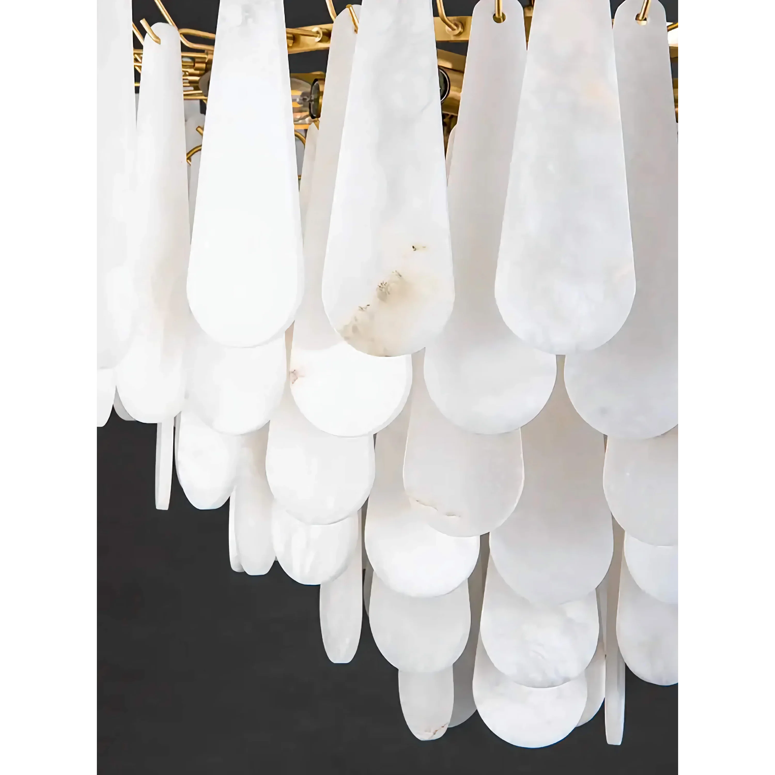 Carved alabaster teardrop and brass frame detail