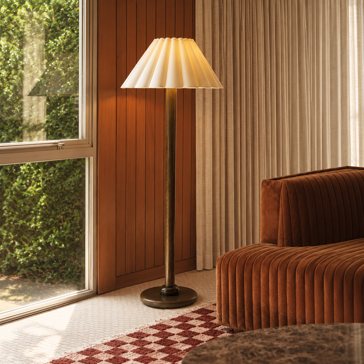 Japandi floor lamp beside a rust corduroy chair and tall window in a timber-panelled sitting room.