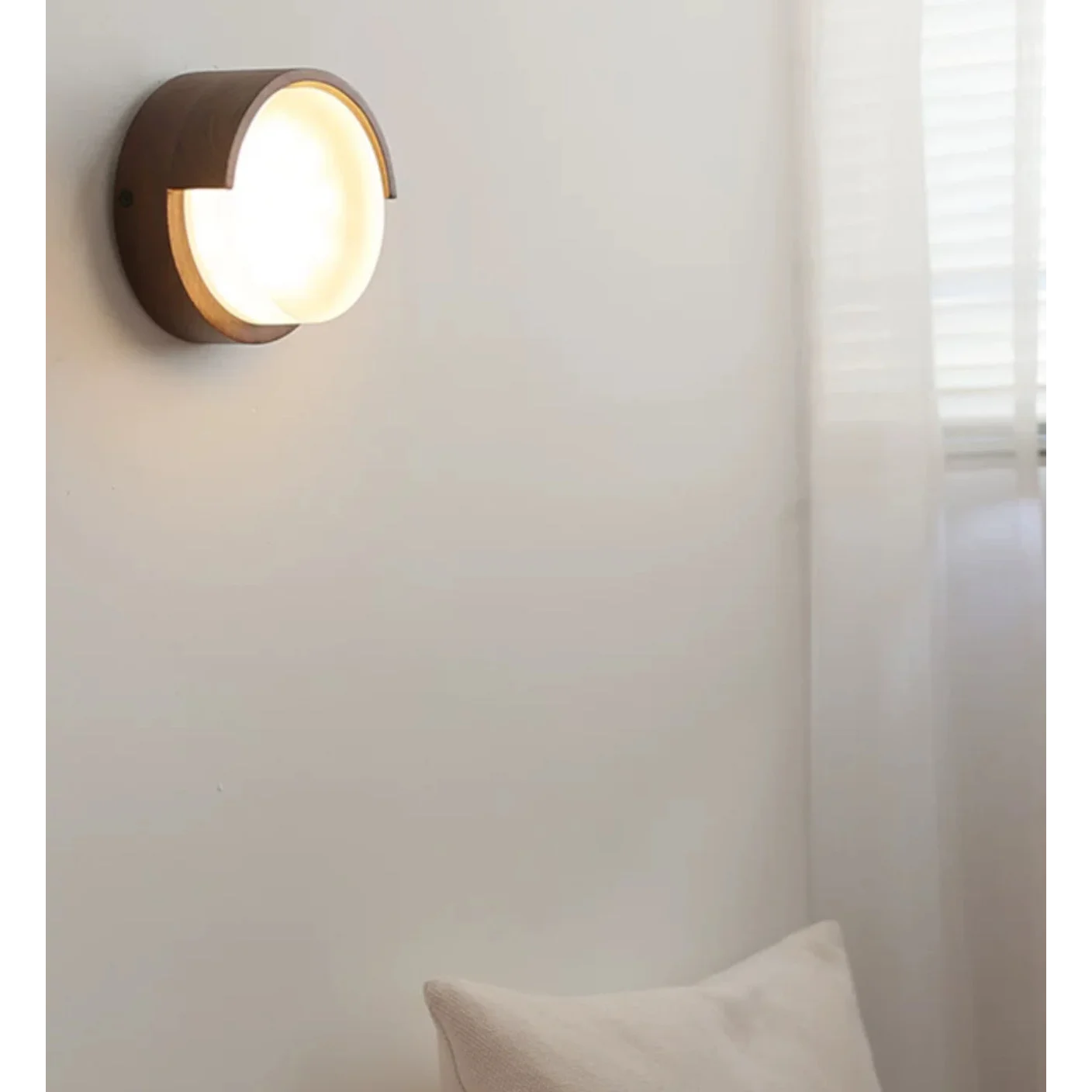 Walnut wall light beside a bed