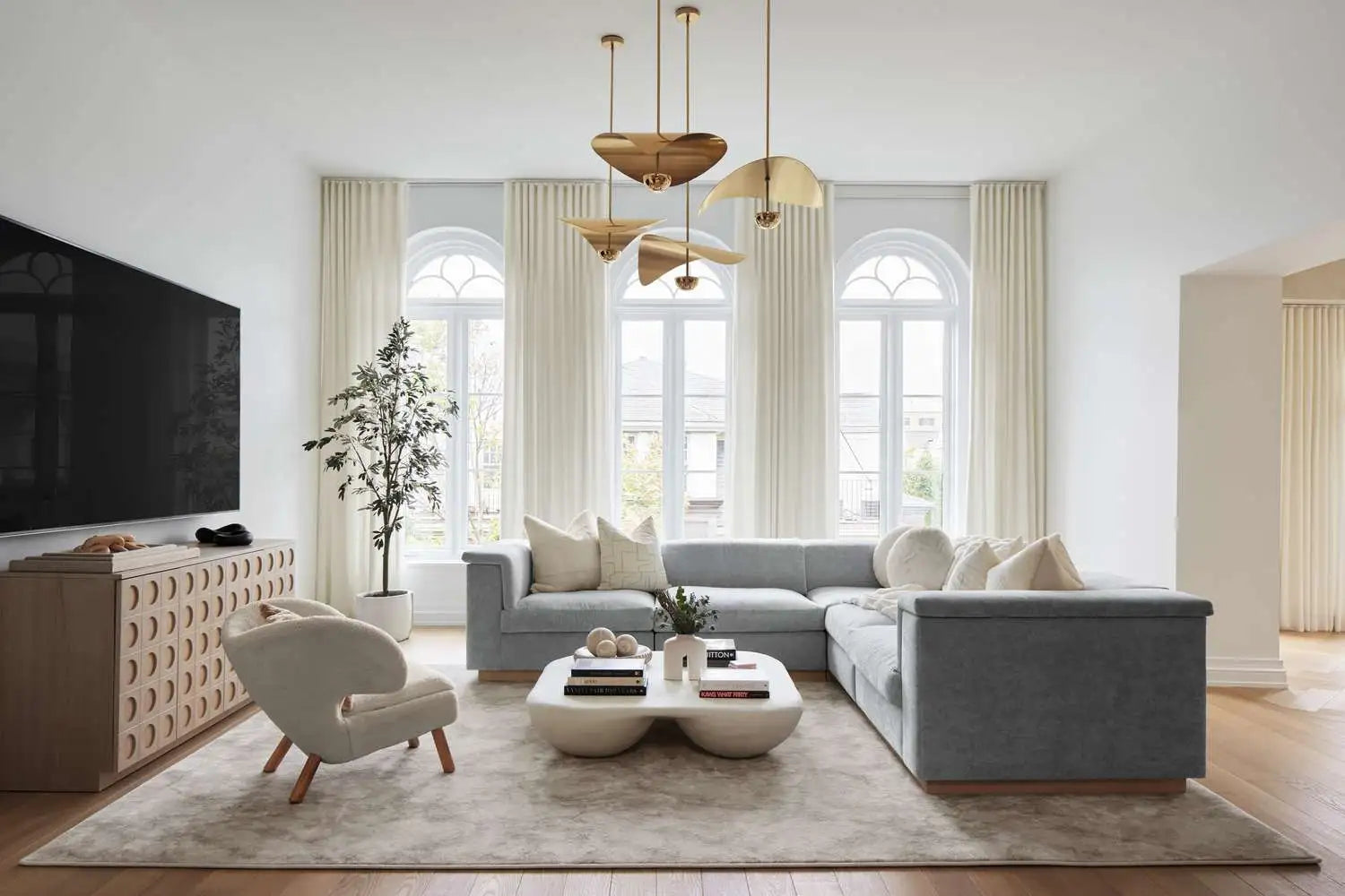Light gray sectional sofa with plush cushions and a modern, minimalist design.