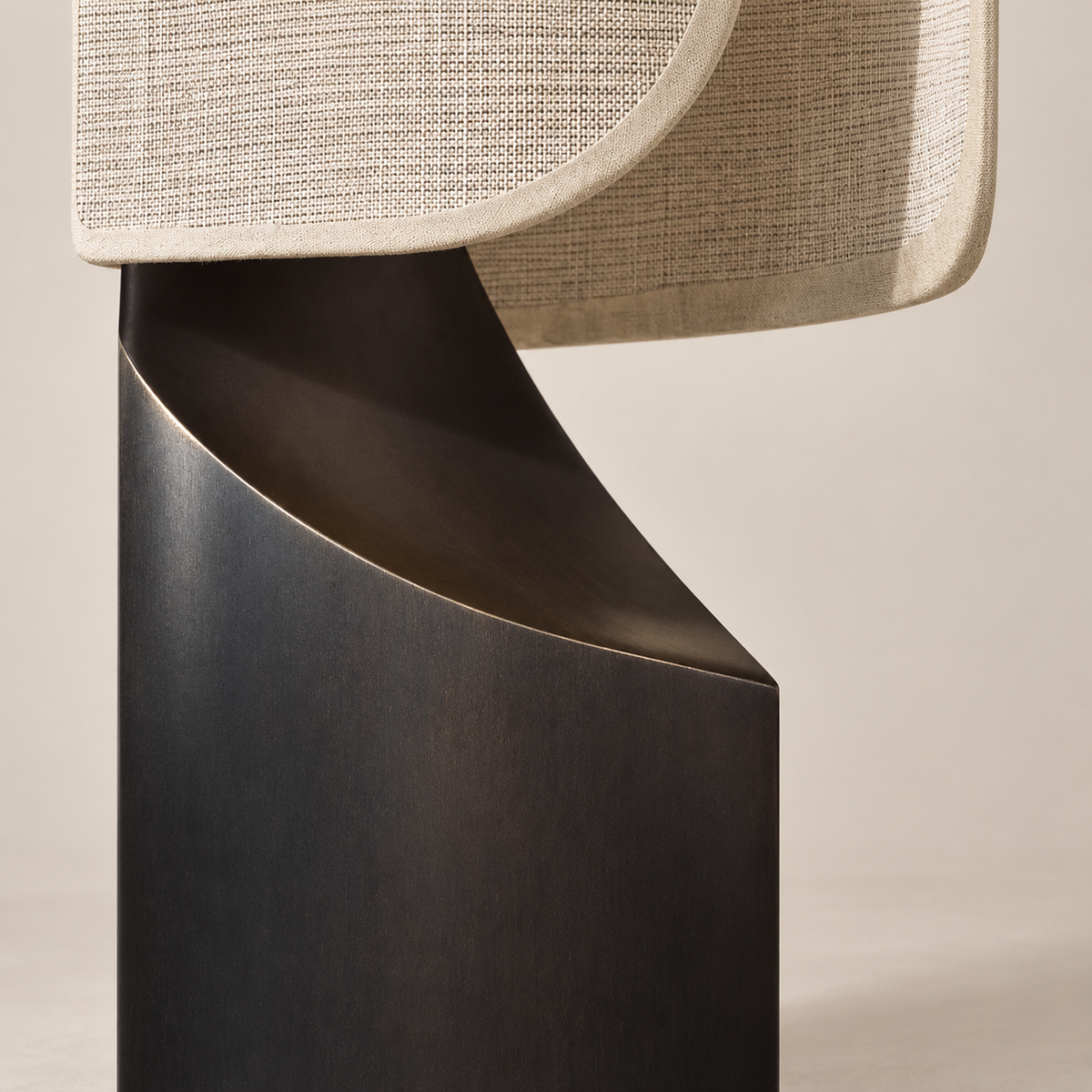 Close view of Maraki’s curved dark base beneath the linen shade.