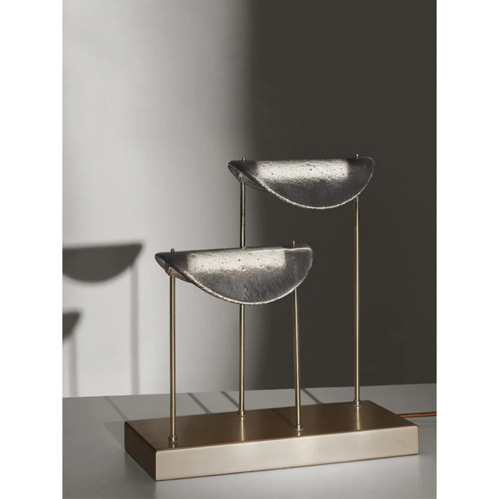 Brass and glass table lamp with studio-shaped diffusers on a console