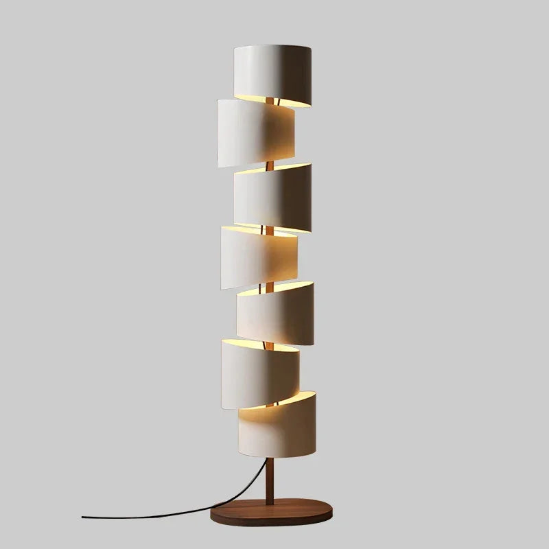 Iron tower floor lamp with stacked cylindrical shades beside a sofa