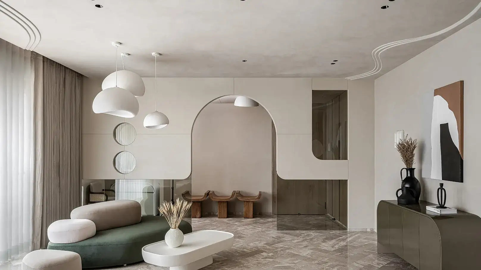 Modern minimalist living room with a sleek, curved green sofa accented by white cushions and a matching white coffee table.