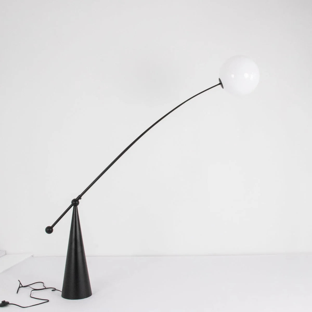 Stainless steel and frosted glass arc floor lamp in a living room