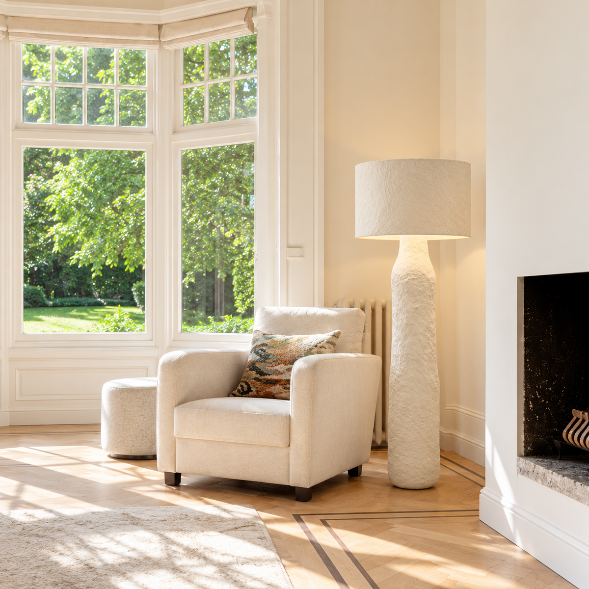 Mountain floor lamp beside a cream armchair in a bright bay-window living room.