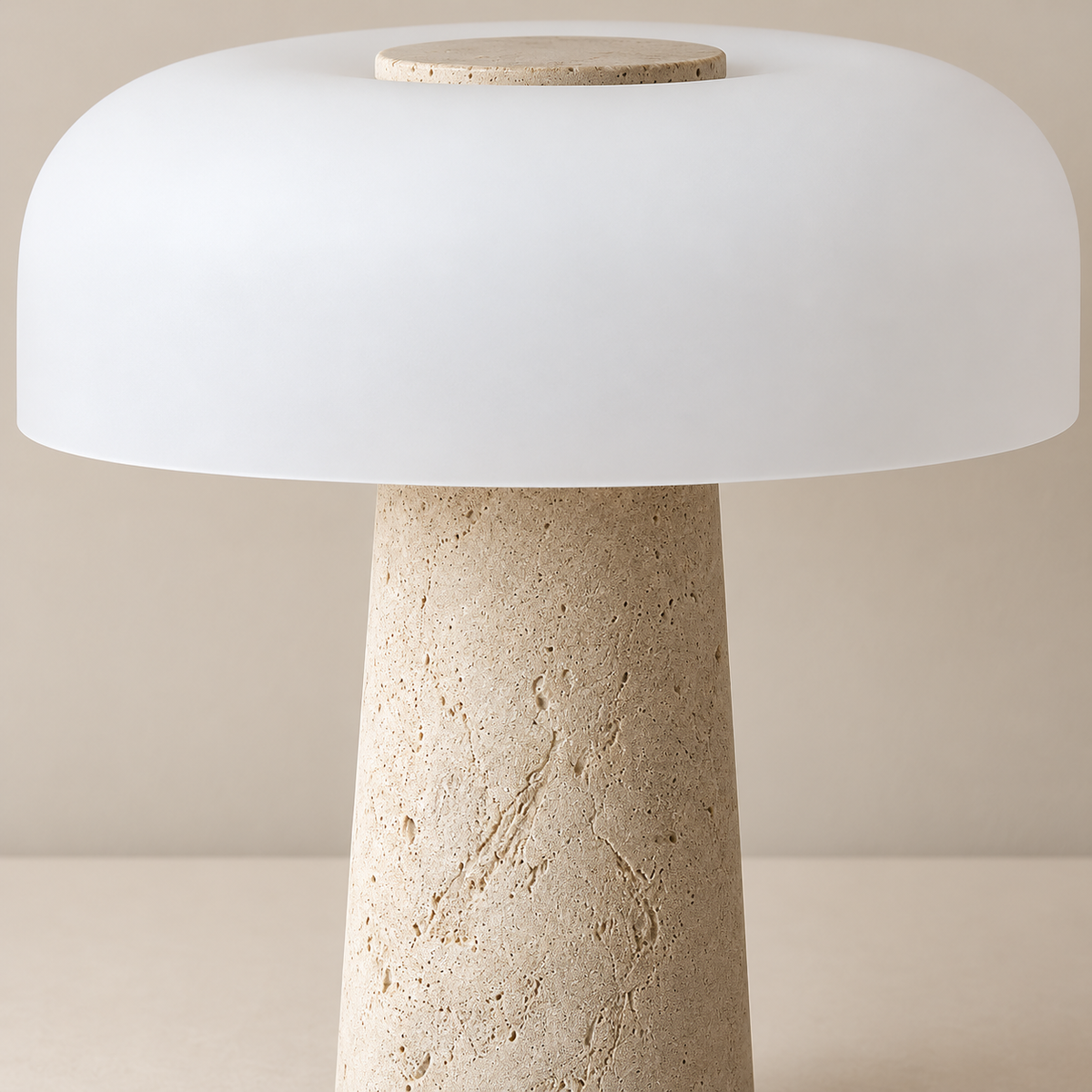 Close view of the porous travertine column and frosted glass shade.