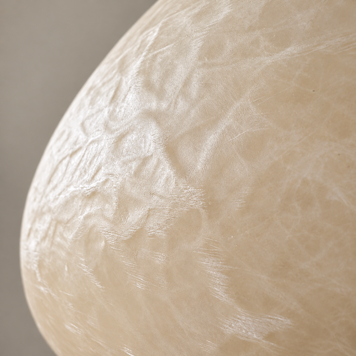 Close view of the softly textured, translucent ivory resin surface of the Ostia floor lamp.