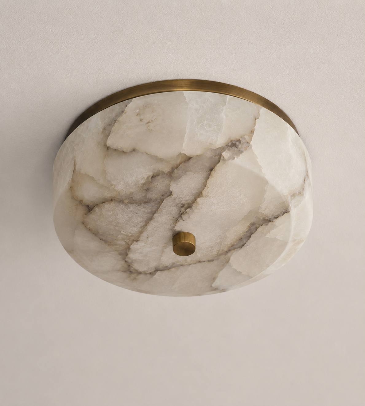 Patterned alabaster flush mount, unlit, with bold grey veining set in an aged brass ring