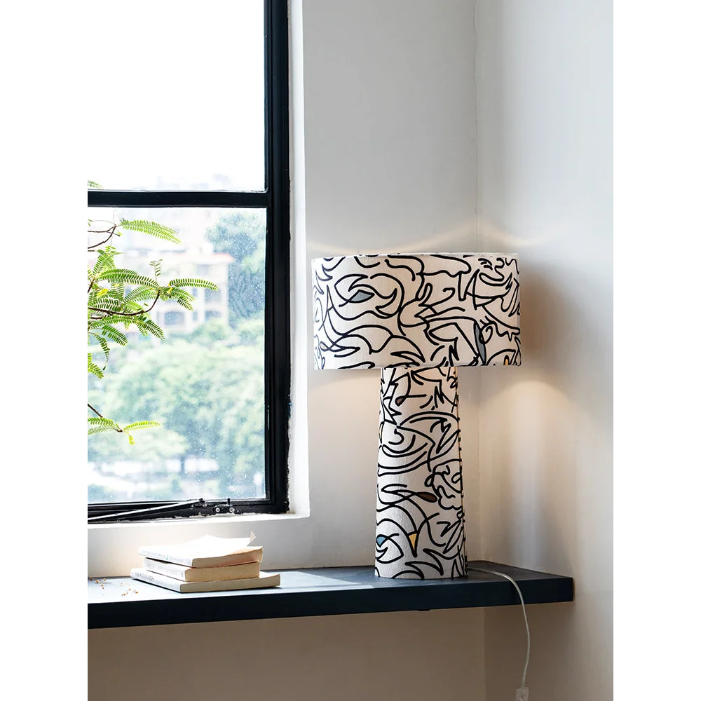 All-over gestural print across the base and wide drum shade glowing soft