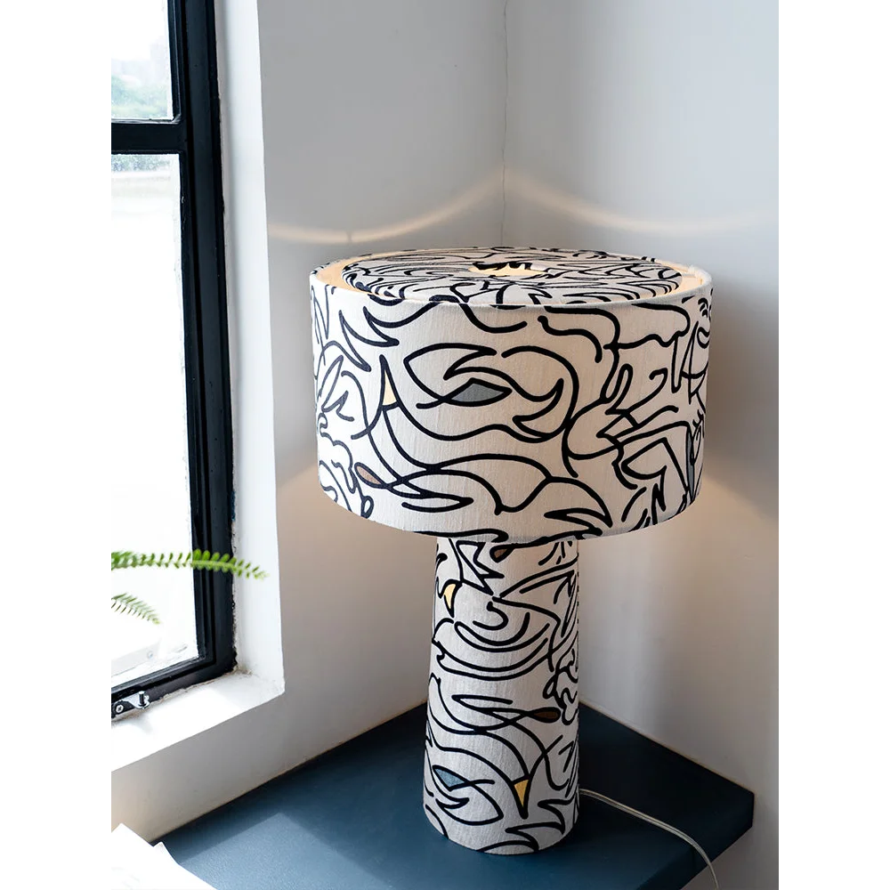 Patterned art table lamp with a gestural-print base and drum shade on a console