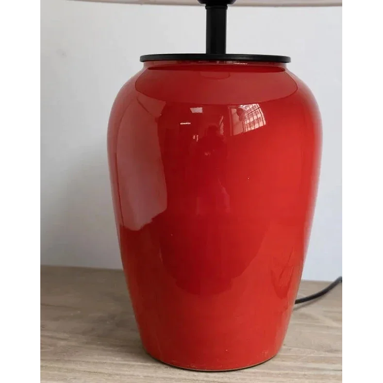 Red ceramic table lamp on a foyer console