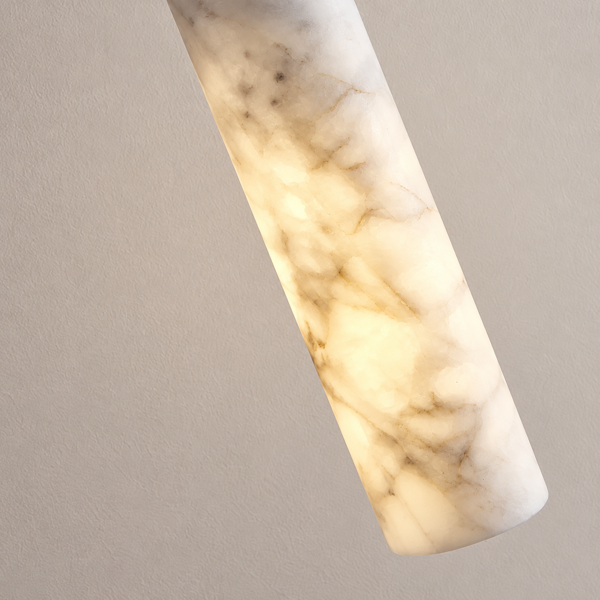 Close view of the Slim Stone pendant's cloudy alabaster and natural grey inclusions.