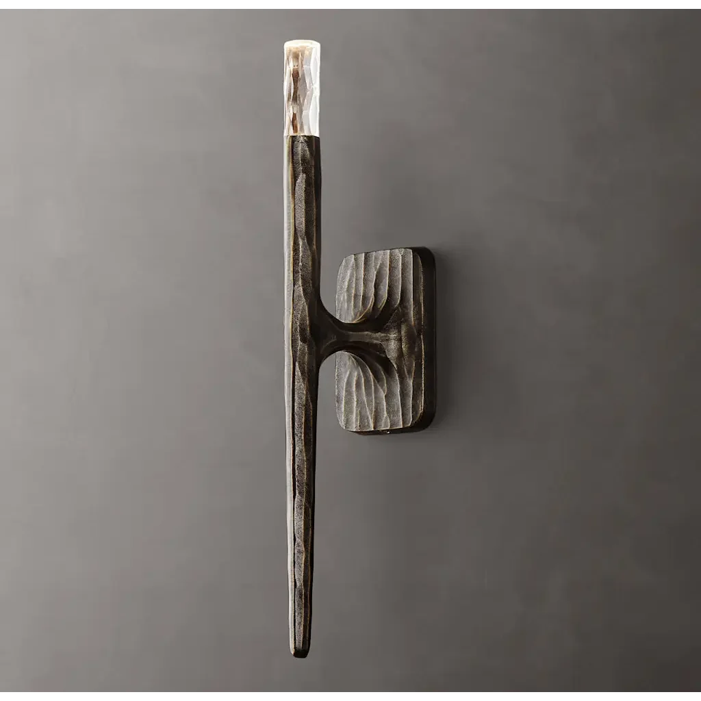 Silver copper stick wall sconce in a hallway